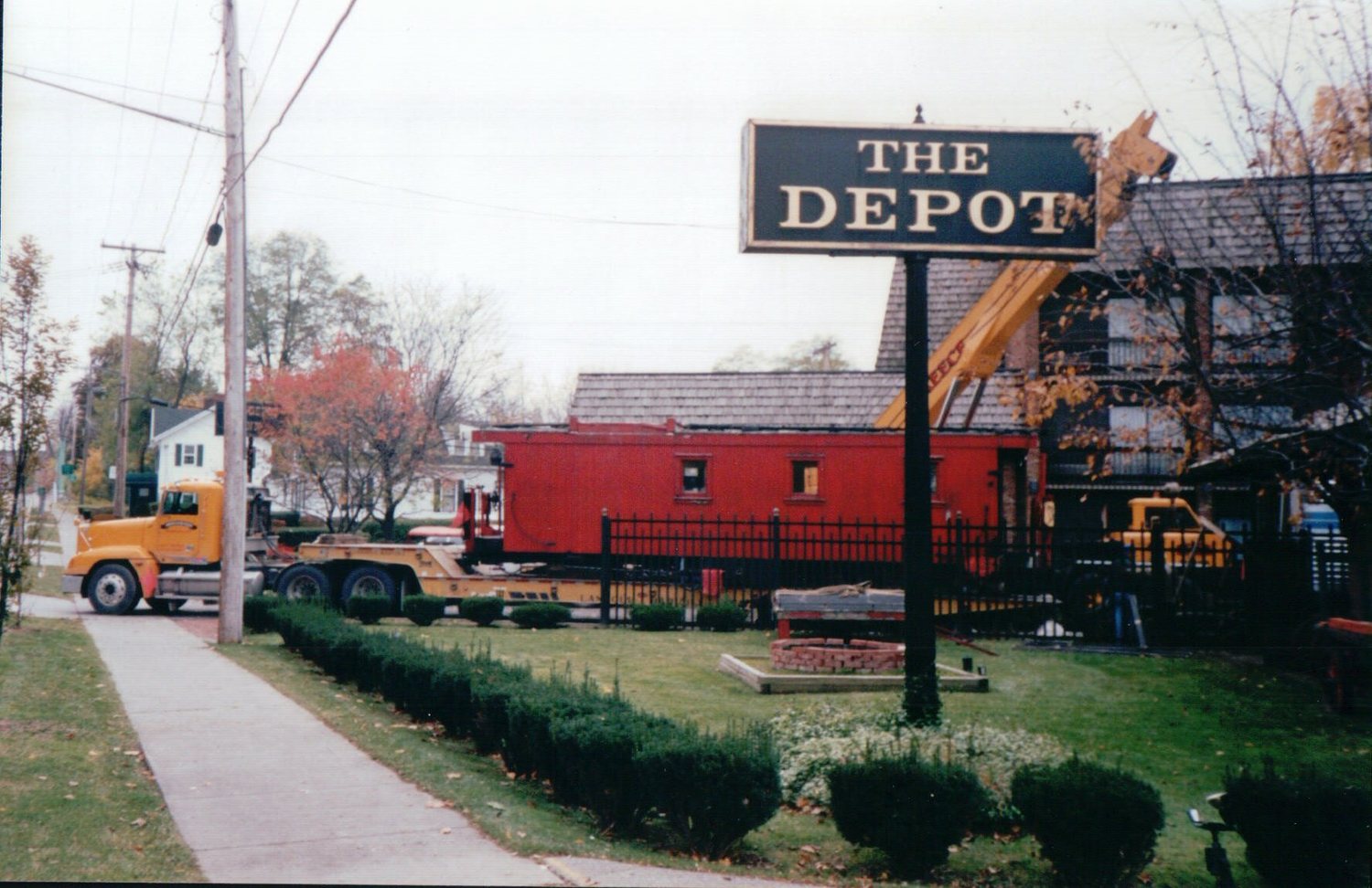 Delivering a red railroad caboose to The Depot