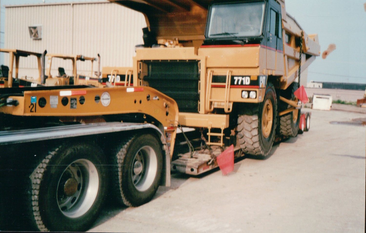 Caterpillar 771D haul truck loaded on a lowboy trailer