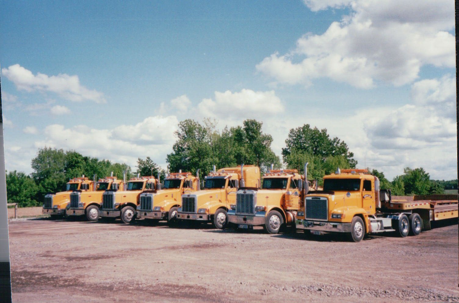 The Mendon Enterprises fleet of heavy haul tractors lined up in the yard