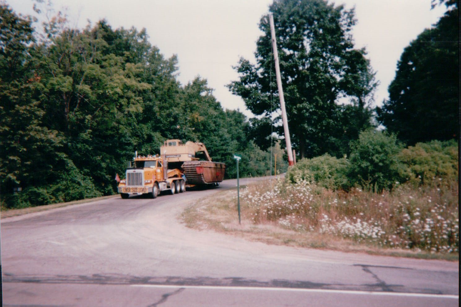 Peterbilt hauling a Caterpillar machine on a rural road