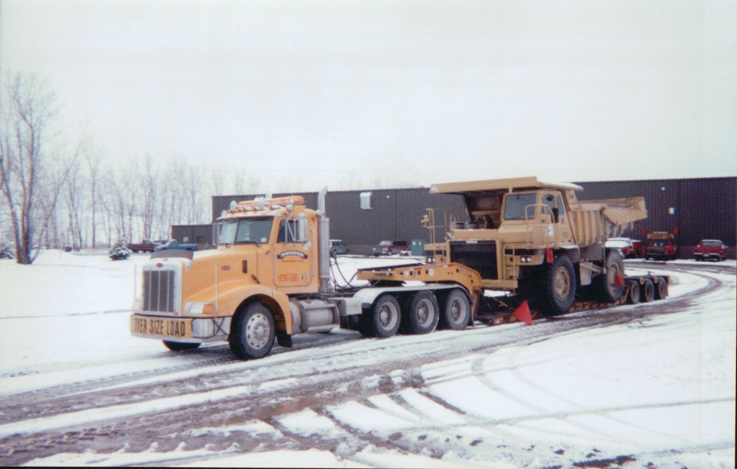 Peterbilt hauling a rigid dump truck in the snow