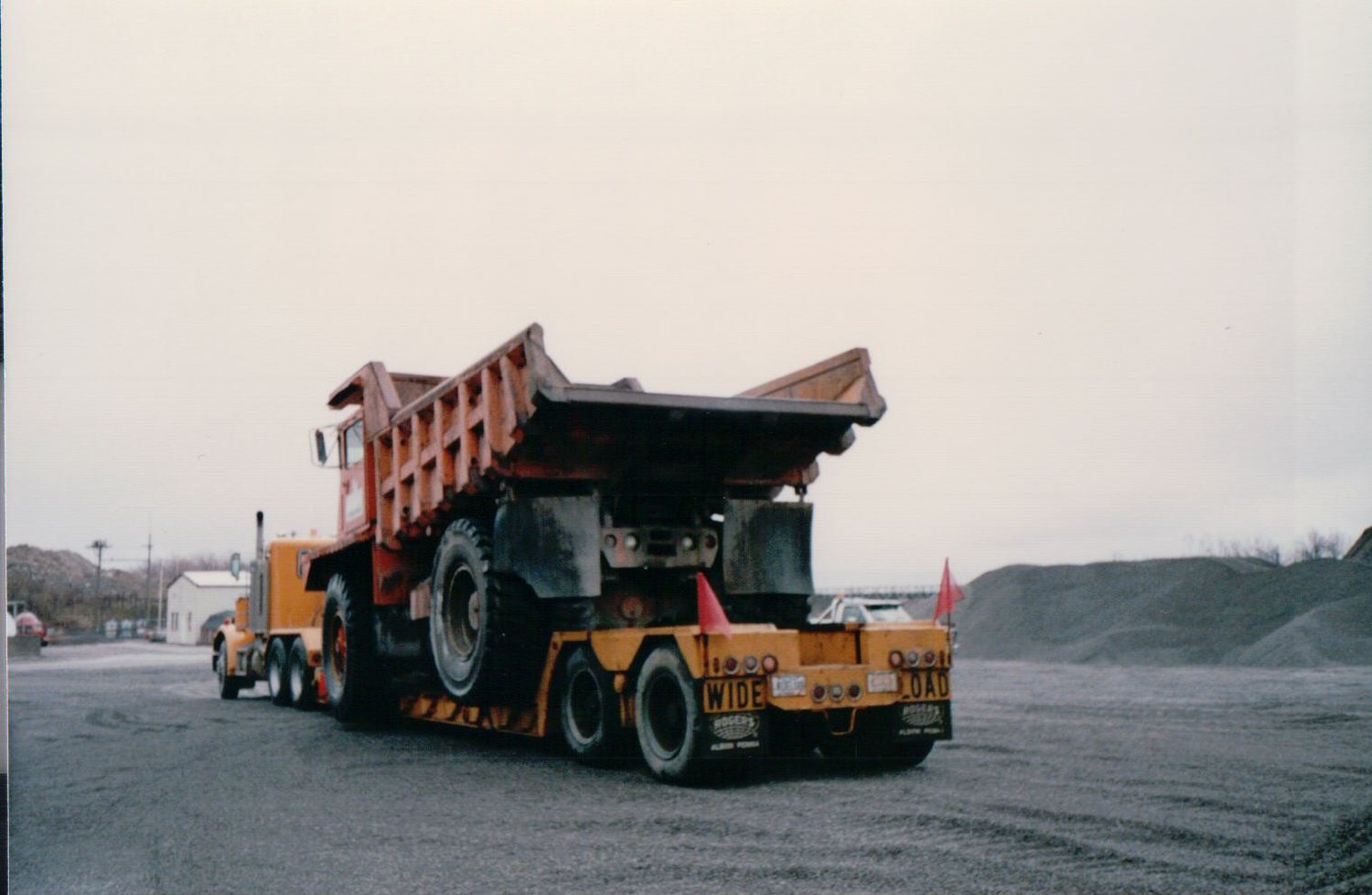 Rear view of a rigid dump truck hauled as a wide load