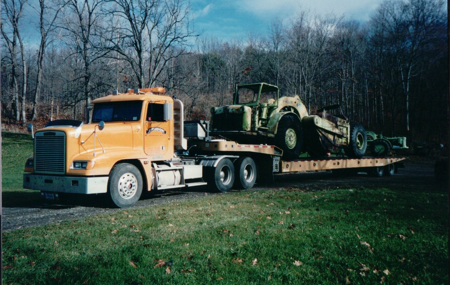 Freightliner hauling a vintage scraper